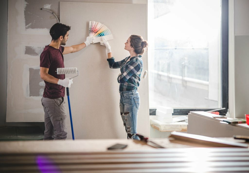 Pareja joven eligiendo colores para pintar su casa